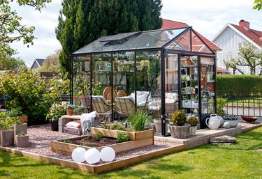 Sort drivhus med ekstra taghøjde og sikkerhedsglas.