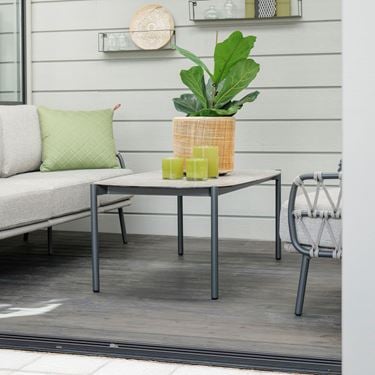 Dandelion sofabord placeret i et udestue med en smuk gul krukke og planter