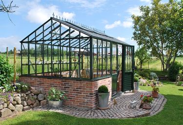 Orangeri på mur grønt drivhus